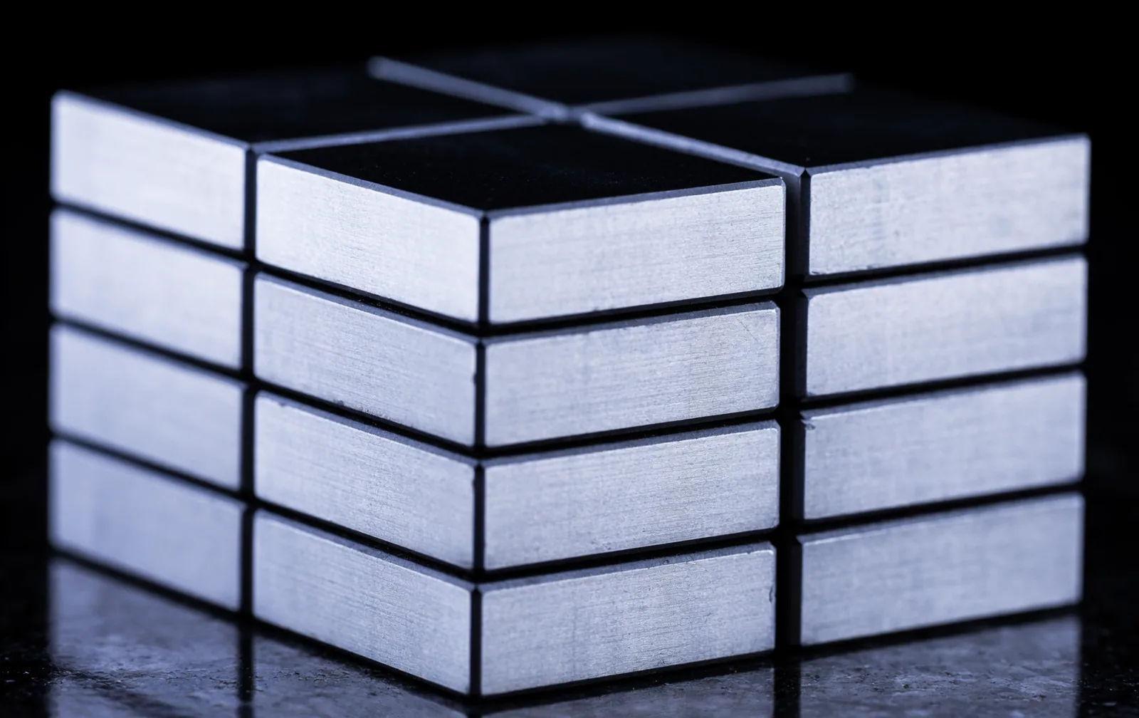 Precision gauge blocks wrung together into a single column, the joints between them almost invisible.